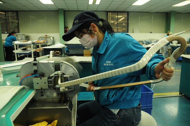 威能公司線圈車間(jiān)高壓線圈組正在進行(háng)成型線圈的機包作業 威能(néng)公司線圈車間高壓線圈組正在進行成型線圈的機包作業